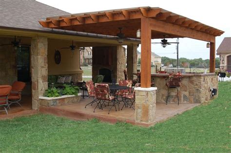 an outdoor kitchen and dining area with patio furniture