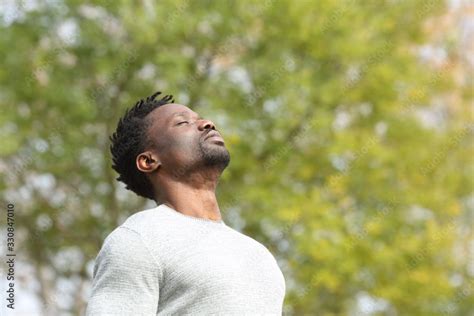 Black serious man breathing fresh air in a park Stock Photo | Adobe Stock