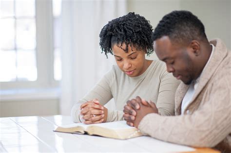 Religious Ethnic Couple Praying With A Bible Stock Photo & More Pictures of Adult - iStock