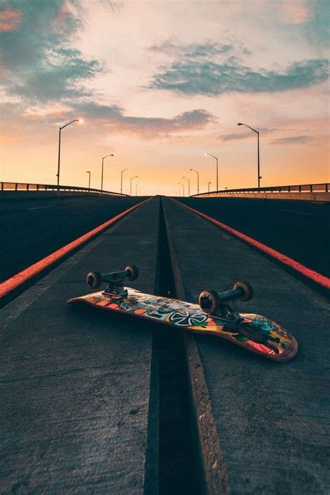 a skateboard is laying on the road at sunset