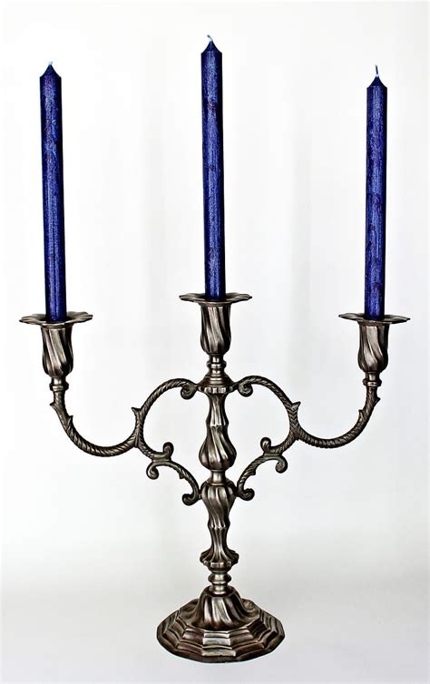 Royalty-Free photo: Gray metal 3-candle holder with three blue unlit candles | PickPik