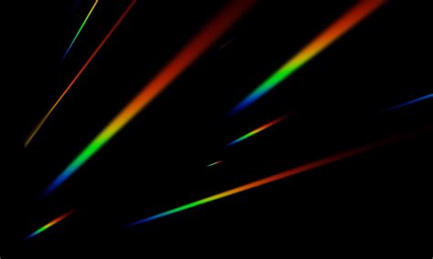 the rainbow light scattered on a black background. the blurry abstract ...