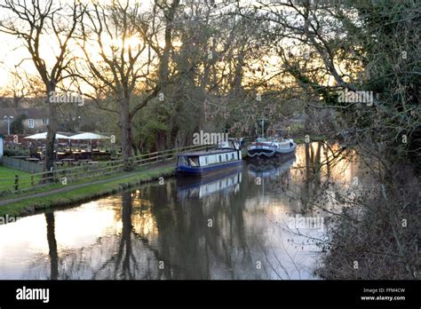 Canal flowing with a beautiful sunset behind the Cunning Man, Burghfield, Reading, Berkshire, UK ...