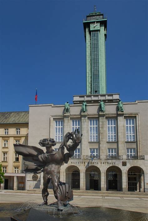 a statue in front of a building with a clock tower