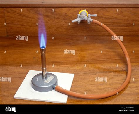 bunsen burner with a roaring blue flame when the air hole is open Stock Photo - Alamy