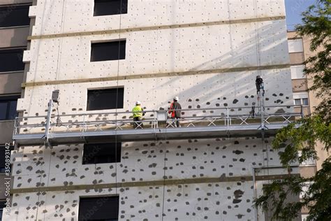 Two workmen laying thermal insulation boards on a building Stock Photo | Adobe Stock