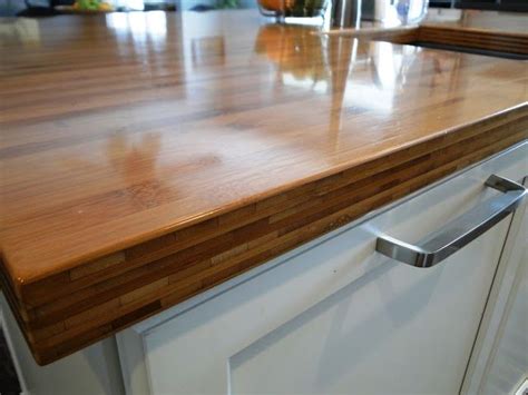 a wooden counter top in a kitchen with white cabinets