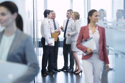 Business people talking in office hallway stock photo