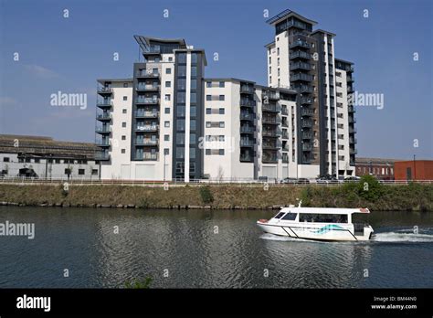 Cardiff Bay Aquabus passing a modern riverside residential block, river Taff Cardiff Wales UK ...