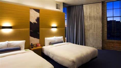 two beds in a hotel room with large windows