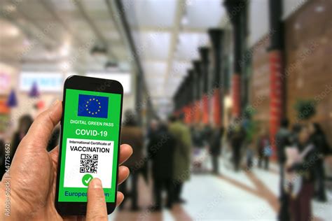 A man in a shopping mall holds a smartphone with the European Union ...