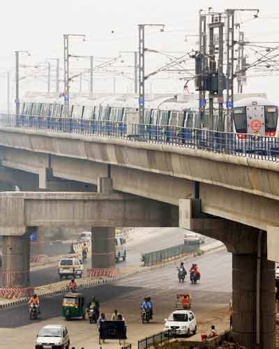 A metro train leaves the Sector-15 station in Noida on the inaugural day of Noida-Delhi metro ...