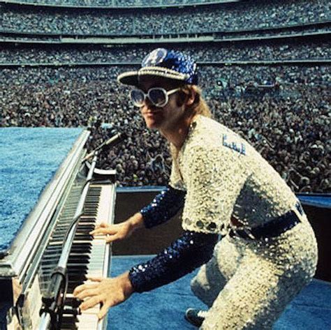 a man with sunglasses playing the piano in front of an audience at a ...