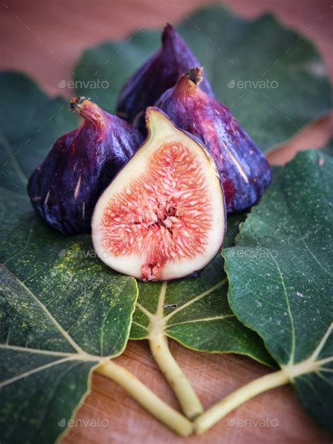 Halved and whole figs on sycamine leaves Stock Photo by ADDICTIVE_STOCK