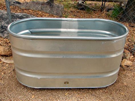 a large metal tub sitting on top of a dirt ground