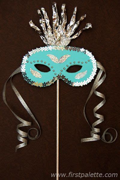 a masquerade mask on top of a stick