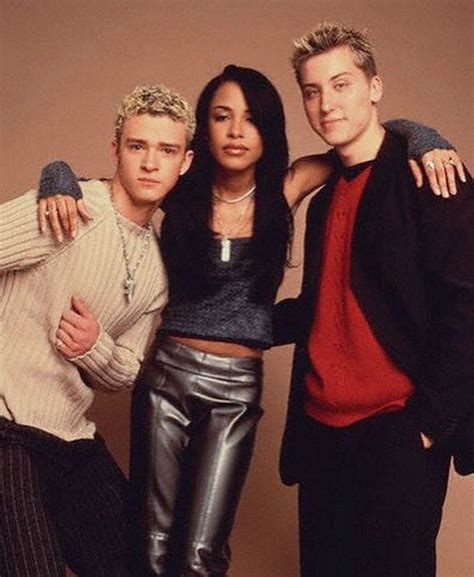 two men and a woman standing next to each other in front of a brown ...