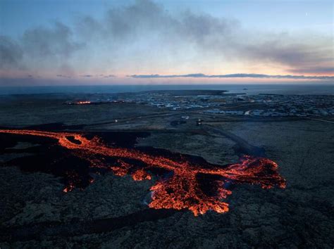 In Iceland, volcano lava flows into a village