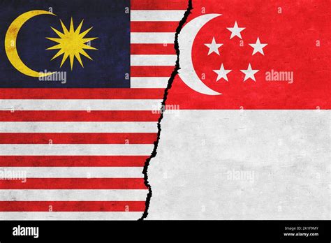 Singapore and Malaysia painted flags on a wall with a crack. Singapore ...