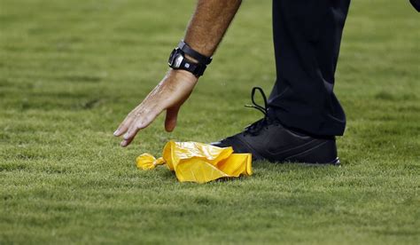 An official picks up a penalty flag off the turf during an NFL ...