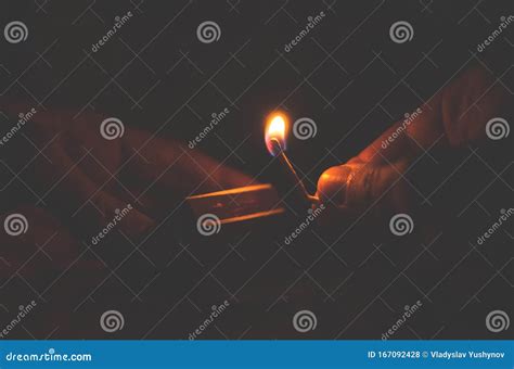 A Match Lit in the Dark in Hands with a Matchbox Stock Photo - Image of ...