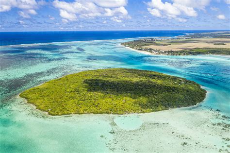 Lush vegetation on Ile aux Aigrettes atoll in the turquoise lagoon, aerial view by drone, Pointe ...