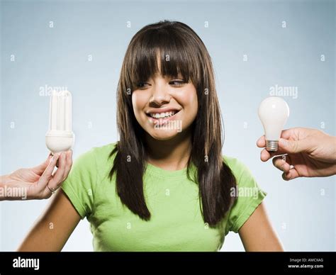 Woman with fluorescent and incandescent light bulbs Stock Photo - Alamy
