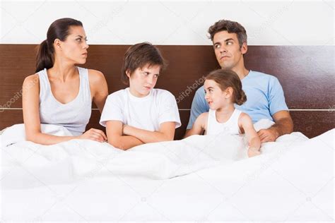 Unhappy family lying in bed Stock Photo by ©mast3r 43555033