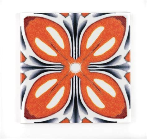 an orange and white flower is shown in the middle of a square tile wall decoration