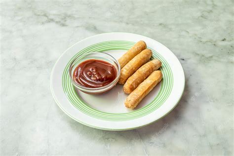 Premium Photo | Plate of cheese tequenos with red sauce for dipping