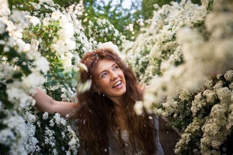 Beautiful young lady with funny smile in spring garden full of white flowers — Stock Photo ...