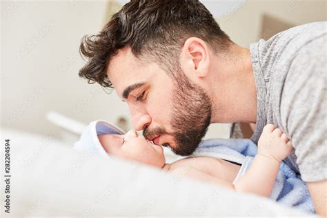 Happy father is kissing his newborn baby Stock Photo | Adobe Stock