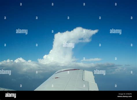 Flying above a storm. Anvil shaped cirroform top of cumulonimbus cloud ...