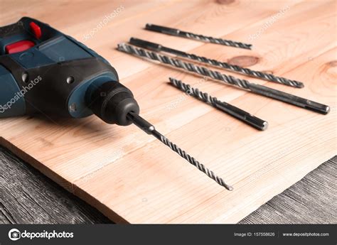 Drill, attachments and wooden board on table in carpenter's workshop, closeup — Stock Photo ...