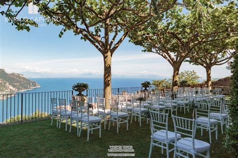 an outdoor wedding setup with white chairs overlooking the ocean