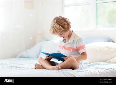 Kids reading book in bed. Bedroom for child. Little boy reading books ...