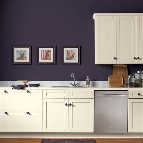 Kitchen walls painted a dark eggplant color are a pleasing contrast with cabinetry that's a warm ...