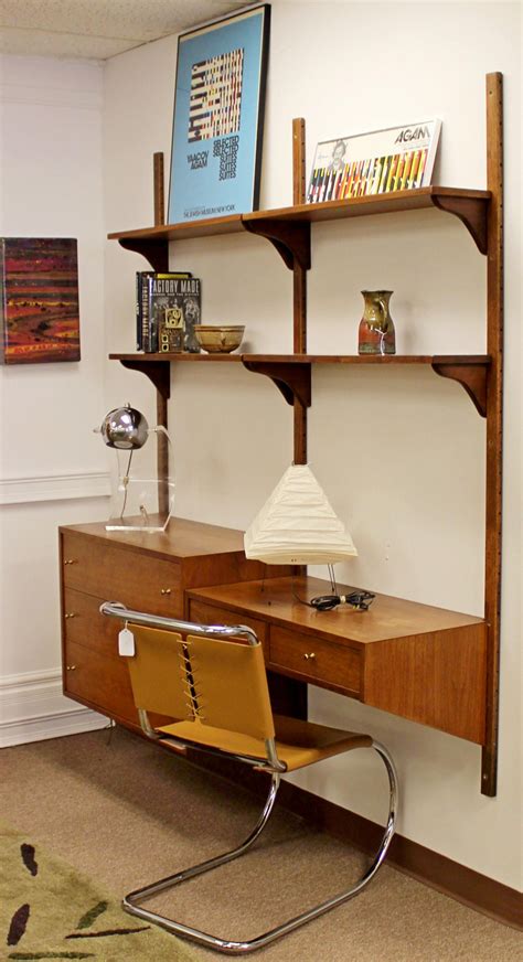 a desk with a chair and shelves on the wall