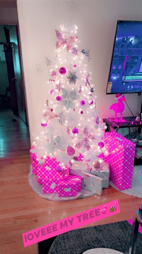 a white christmas tree decorated with pink and silver ornaments in a ...