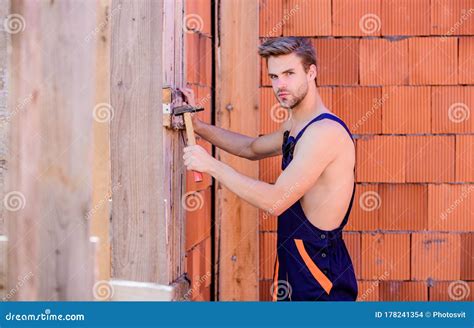 Muscular Worker with Hammer Brick Wall Background. Construction Concept Stock Photo - Image of ...