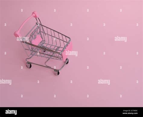 Small grocery cart with big unusual cucumber on pink background Stock Photo - Alamy