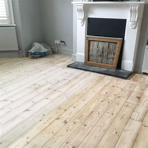 Pine wooden floorboards half treated with Finney's white wood dye ...