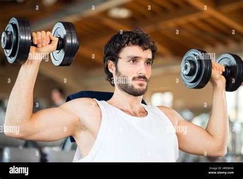 Man lifting weights in a gym Stock Photo - Alamy