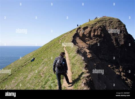 People climbing the steep trail to God's Thumb, a volcanic plug that is ...