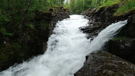 Nature sound of a loud waterfall flowing down the wet forest