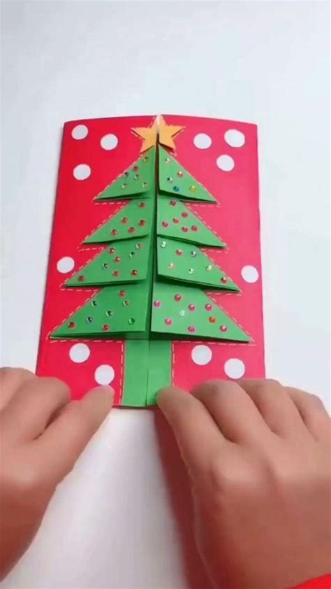 someone is making a christmas tree out of construction paper and glues ...