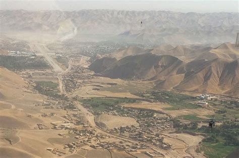 Approach to Qala-I-Naw - An aerial view of a desert town and mountains ...