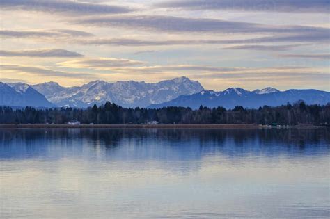 Germany, Bavaria, Sankt Heinrich, Lake Starnberg at dusk with Wetterstein mountains in ...