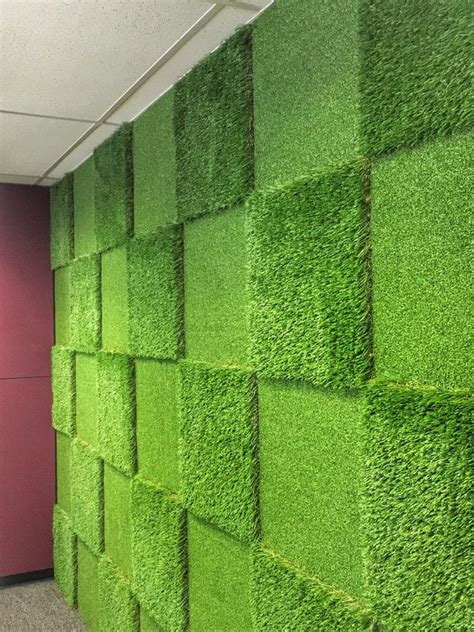 an office cubicle with green grass covering the walls