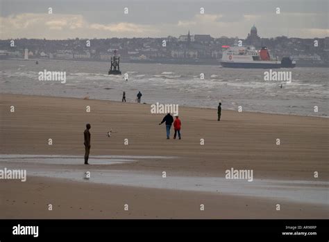 Statues and people on Crosby Beach, Merseyside, UK Stock Photo - Alamy